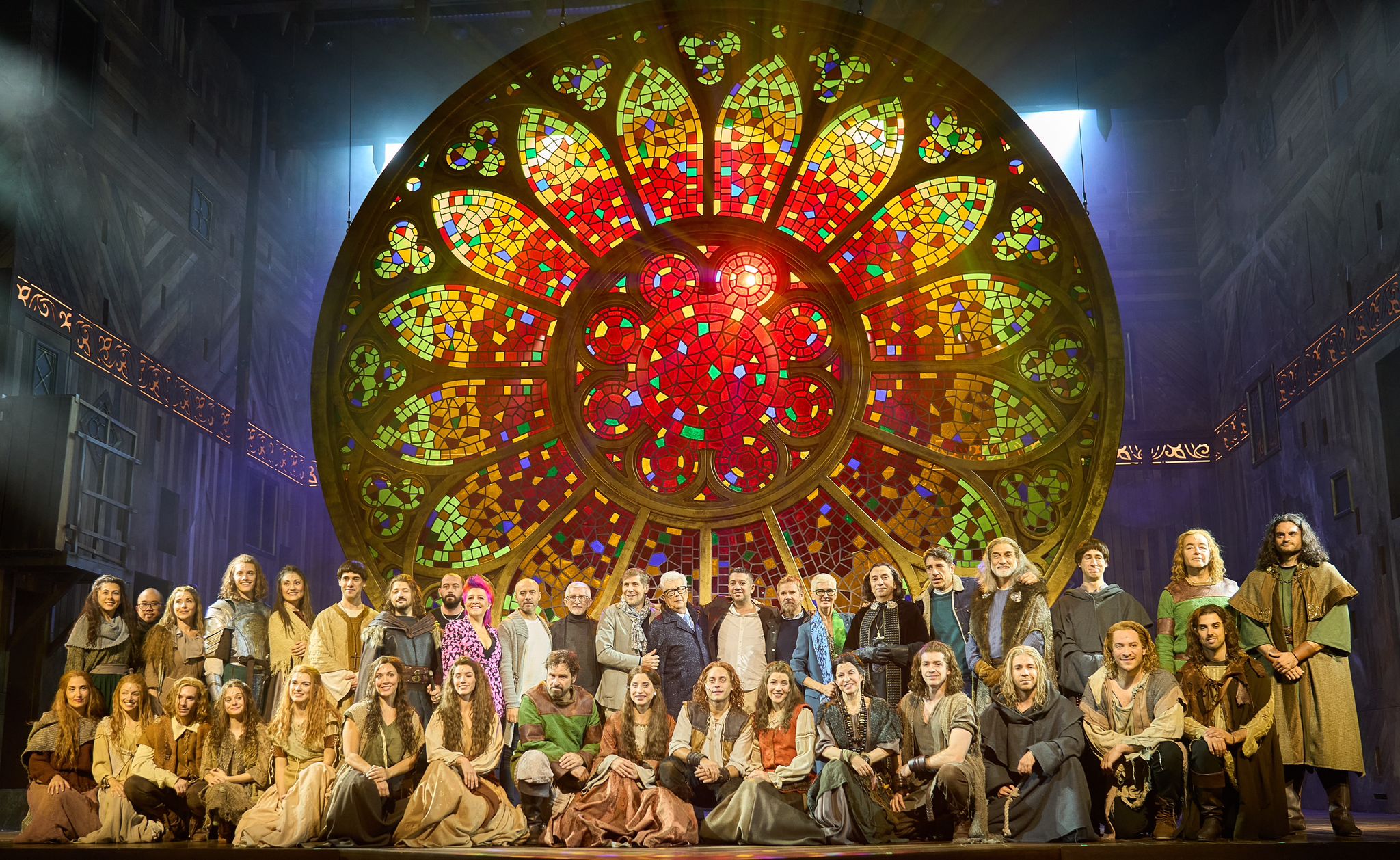 Fotografía de familia del elenco del musical "Los pilares de la tierra" con su autor, Ken Follet